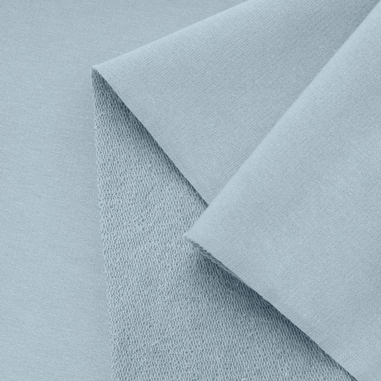 Close-up of blue French terry knit – smooth front and looped back structure.