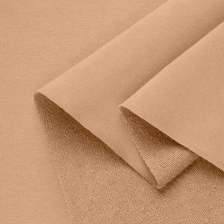 Folded beige sweatshirt knit fabric – organic cotton with visible loopback texture.