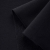 Close-up of black loopback fabric displaying the front side and diagonal loopback texture on the reverse side