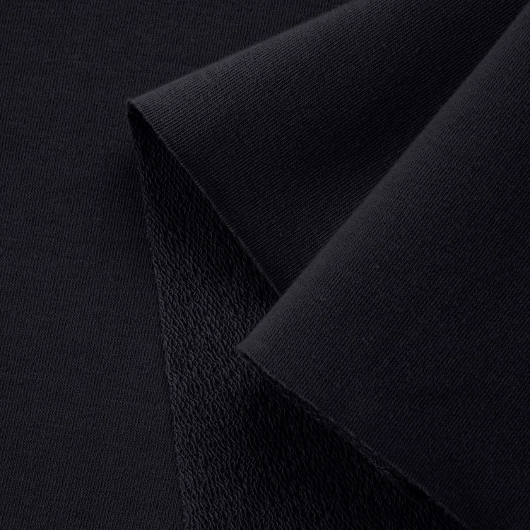 Close-up of black loopback fabric displaying the front side and diagonal loopback texture on the reverse side