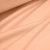 Draped peach jersey fabric – lightweight, elastic material ideal for clothing and handmade use.
