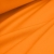 Draped orange jersey fabric – soft, stretchy material ideal for sewing activewear.