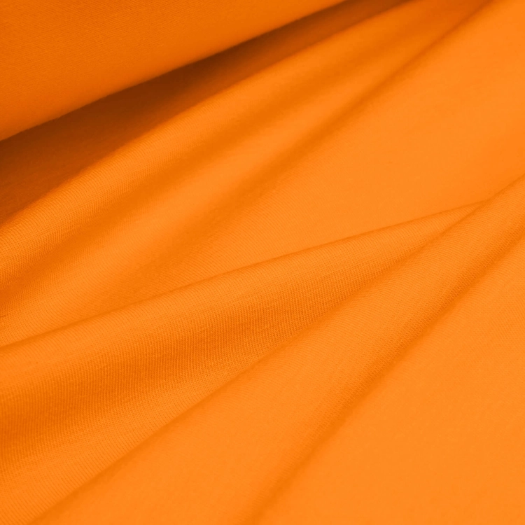 Draped orange jersey fabric – soft, stretchy material ideal for sewing activewear.