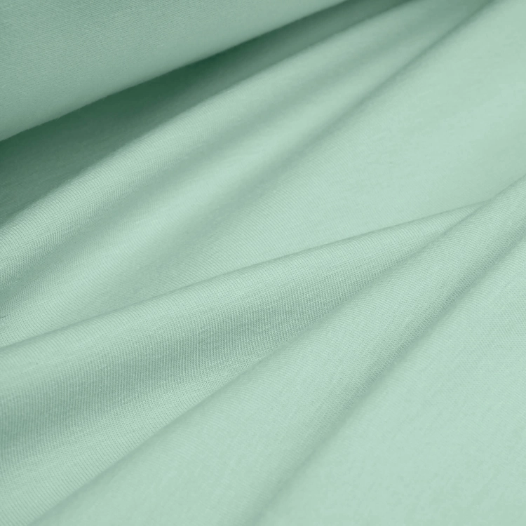 Draped green cotton jersey – breathable, elastic fabric perfect for kidswear and spring fashion.