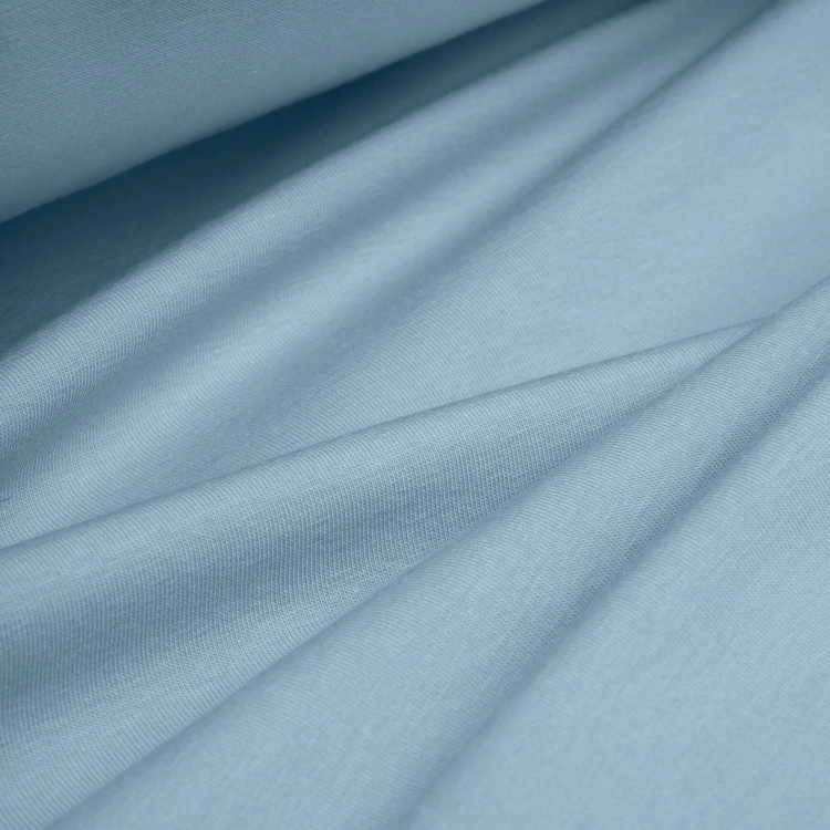 Draped folds of Blue 564 fabric – soft, stretchy knit in a dusty blue tone, ideal for comfortable clothing.