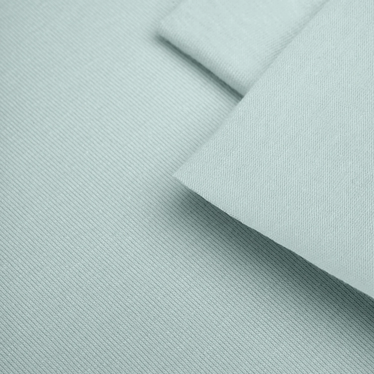 Close-up of Green 23 jersey – fine single jersey texture in a pale pastel green.